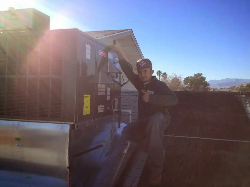HVAC technician performing AC Tune-Up on a rooftop unit in Lincolnton